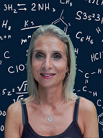 Woman standing in front of organic chemistry symbols and formulas smiling